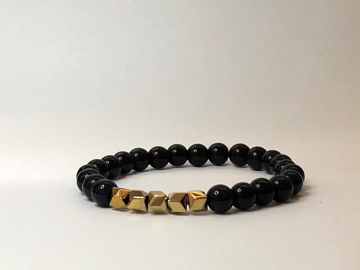 Shiny black onyx bracelet with gold polygonal iron