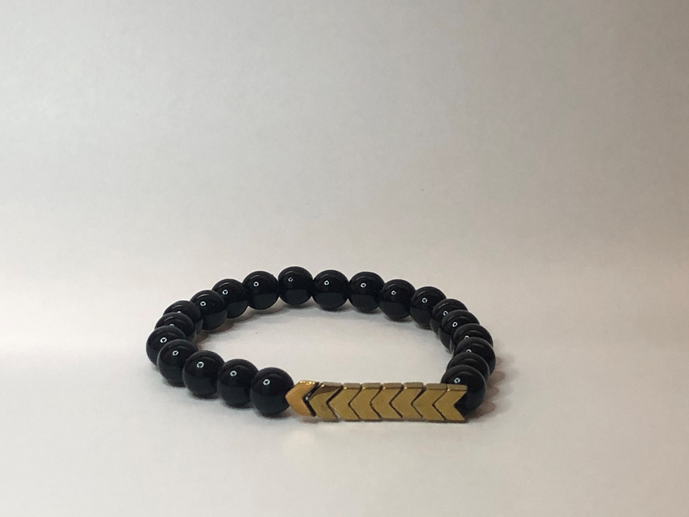 Glossy black onyx bracelet with gold arrow